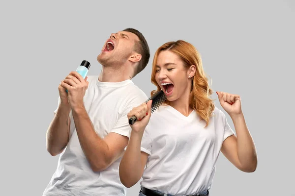Feliz pareja cantando a cepillo y loción — Foto de Stock