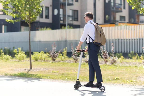 Hombre de negocios con mochila a caballo scooter eléctrico —  Fotos de Stock