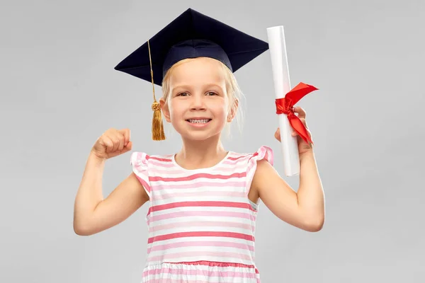 Маленька дівчинка в мінометній дошці з дипломом — стокове фото