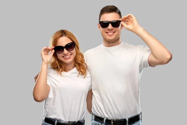 Feliz pareja en camisetas blancas y gafas de sol — Foto de Stock