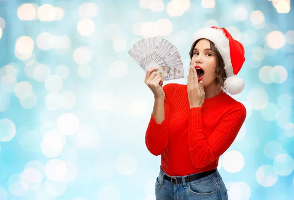 Zaskoczony kobieta w Santa kapelusz z pieniędzy — Zdjęcie stockowe