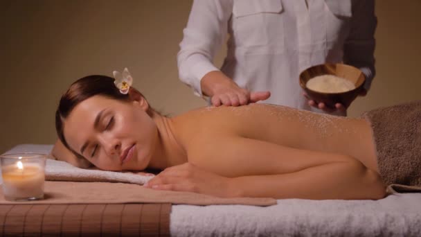 Vacker ung kvinna som har salt massage på spa — Stockvideo