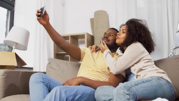 Feliz pareja mudándose a nuevo hogar y tomando selfie — Vídeos de Stock