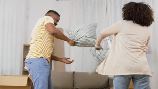 Feliz pareja teniendo almohada lucha en nuevo hogar — Vídeos de Stock