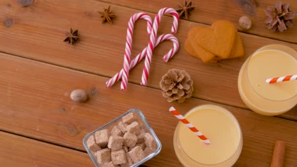 Glazen eierpunch, ingrediënten en specerijen op hout — Stockvideo