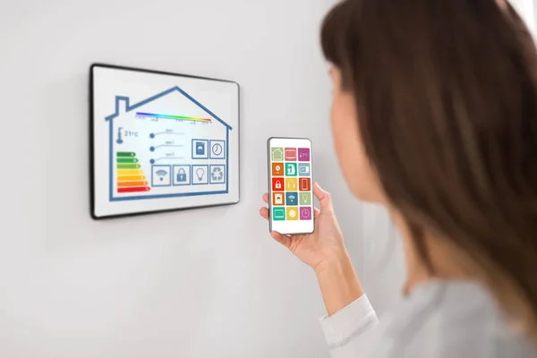 Vrouw met behulp van tablet pc en smartphone in smart home — Stockfoto