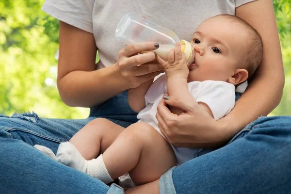 Close up of mother feeding baby with milk formula — Stock Photo, Image