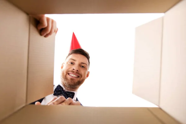 Jovem feliz olhando para o presente de aniversário aberto — Fotografia de Stock