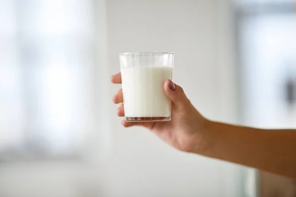 Закрыть женскую руку, держа стакан молока — стоковое фото
