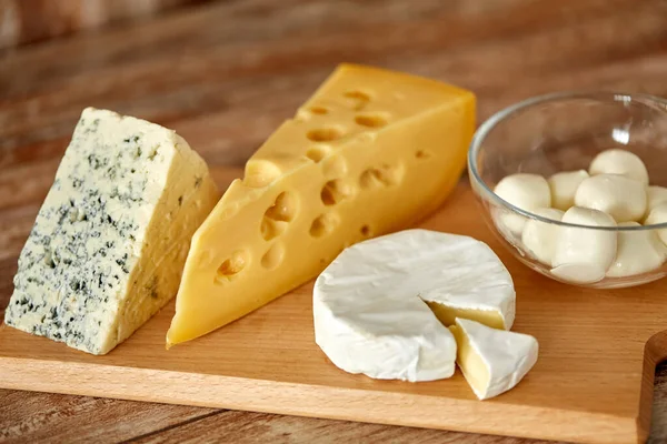 Différents types de fromage sur planche à découper en bois — Photo