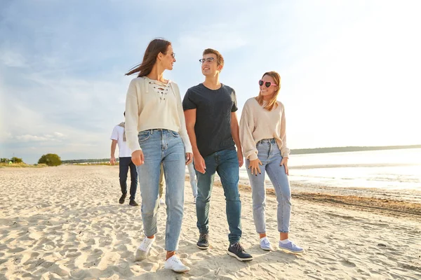 Amigos felizes andando ao longo da praia de verão — Fotografia de Stock