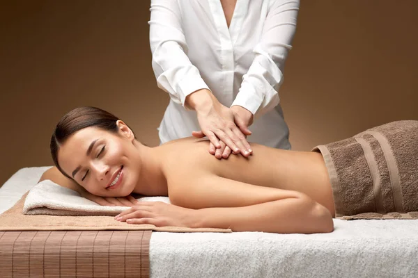 Mujer acostada y teniendo masaje de espalda en el spa — Foto de Stock
