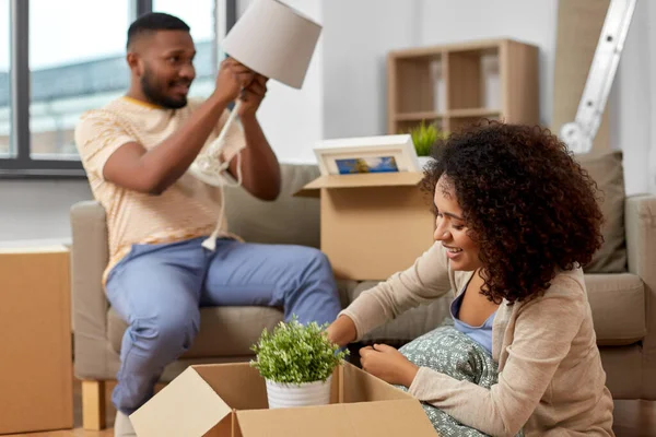 Lyckliga par packning lådor och flytta till nytt hem — Stockfoto