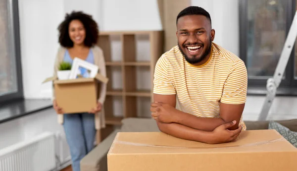 Feliz pareja con cajas mudándose a un nuevo hogar — Foto de Stock