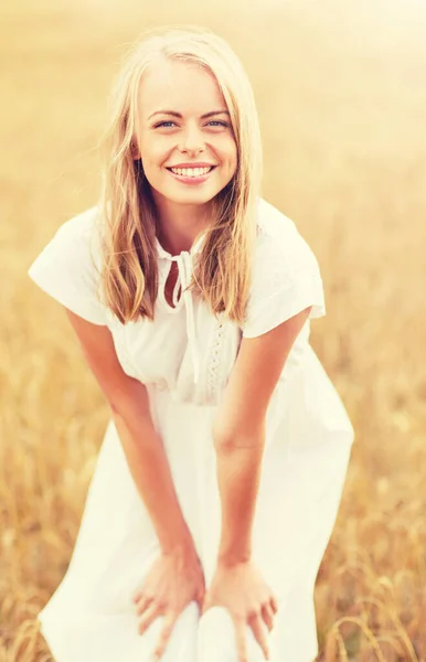 Giovane donna sorridente in abito bianco sul campo di cereali — Foto Stock