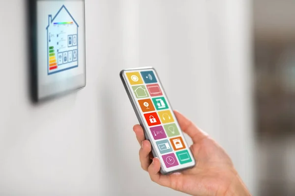 Hand mit Smart-Home-Symbolen auf Smartphone-Bildschirm — Stockfoto