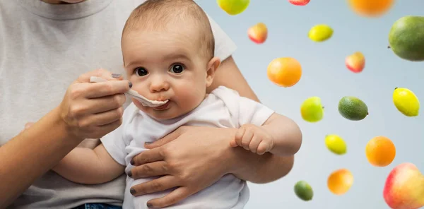 Primer plano de la madre con cuchara alimentando al pequeño bebé — Foto de Stock