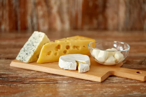 Diversi tipi di formaggio sul tagliere di legno — Foto Stock