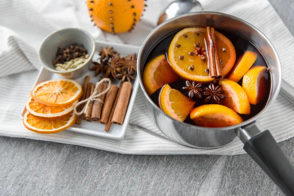 Olla con vino caliente caliente, rodajas de naranja y especias — Foto de Stock