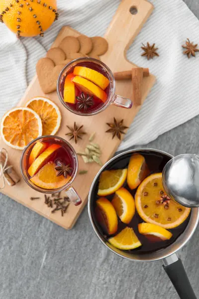 Pentola con vin brulè caldo, fette di arancia e spezie — Foto Stock