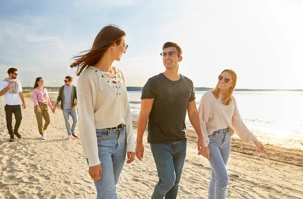 Amigos felices caminando por la playa de verano — Foto de Stock