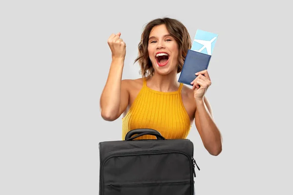 Heureuse jeune femme avec billet d'avion et sac de voyage — Photo