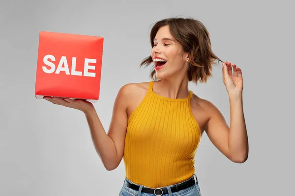 Happy smiling young woman posing with sale sign — Stock Photo, Image