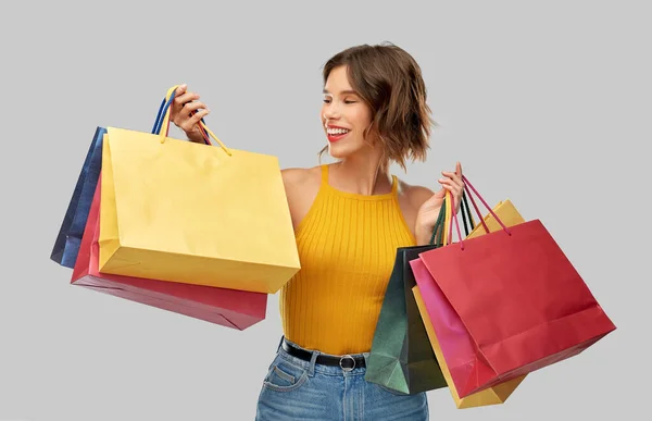 Gelukkig lachende jonge vrouw met boodschappentassen — Stockfoto