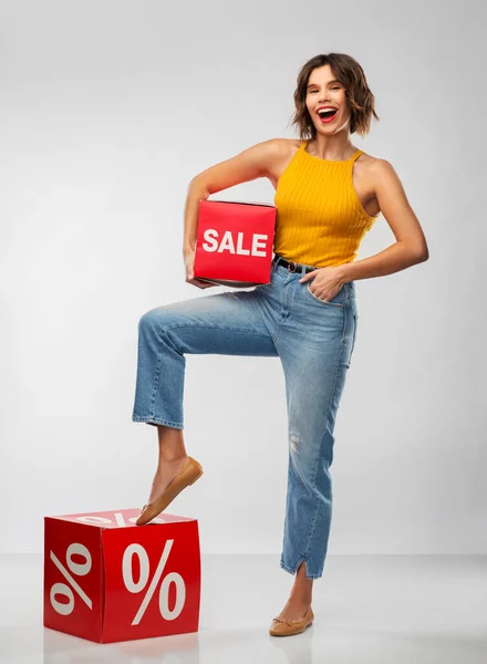 Glad leende ung kvinna med försäljning tecken — Stockfoto