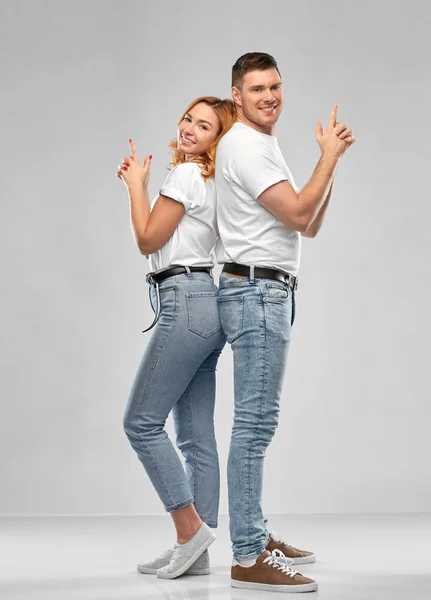 Para w białych koszulkach robi gest pistoletowy — Zdjęcie stockowe