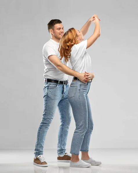 Retrato de casal feliz em branco camisetas dançando — Fotografia de Stock