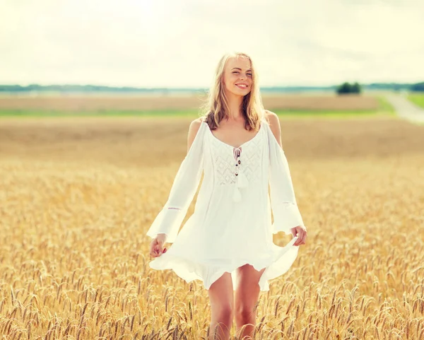 Sonriente joven en vestido blanco en el campo de cereales — Foto de Stock