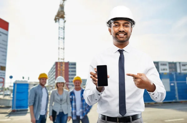 Arquiteto mostrando smartphone no local de construção — Fotografia de Stock