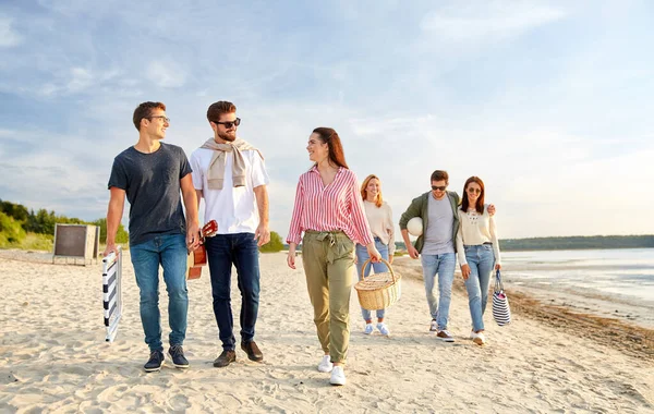 Amigos felizes andando ao longo da praia de verão — Fotografia de Stock