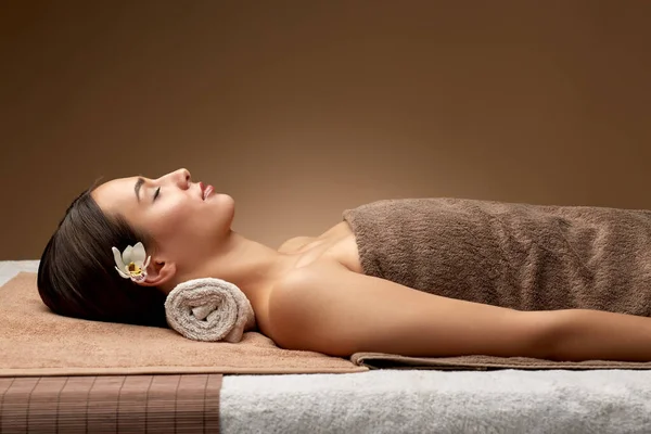 Jovem deitada no spa ou salão de massagens — Fotografia de Stock