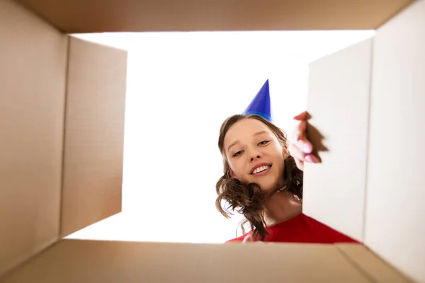 Happy young woman looking into open birthday gift — Stock Photo, Image