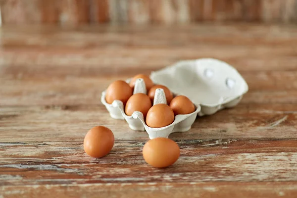 Gros plan des œufs dans une boîte en carton sur une table en bois — Photo