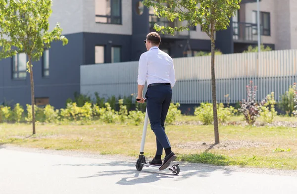 Joven hombre de negocios montar scooter eléctrico al aire libre —  Fotos de Stock