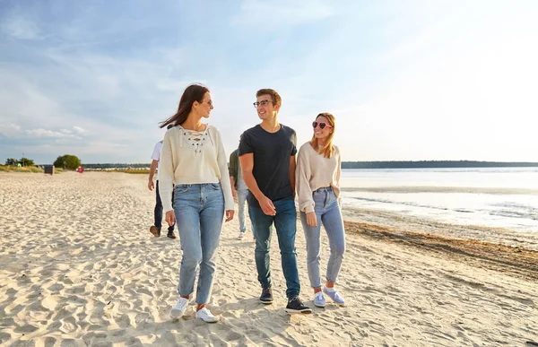 Szczęśliwy przyjaciele spacery wzdłuż letniej plaży — Zdjęcie stockowe