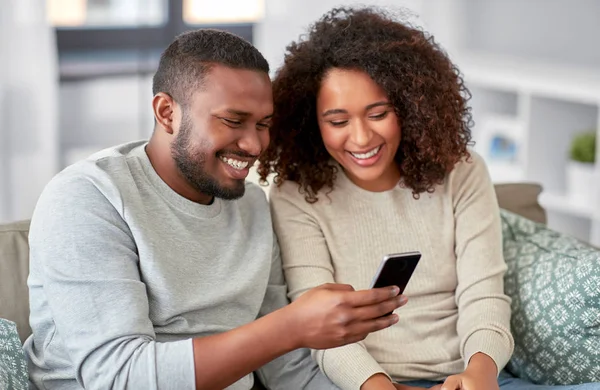 Africano casal americano com smartphone em casa — Fotografia de Stock