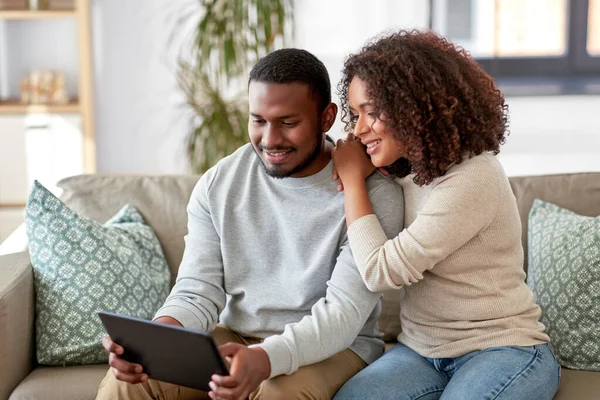 Casal afro-americano com tablet pc em casa — Fotografia de Stock