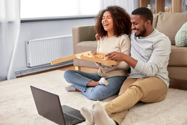 Šťastný africký americký pár jíst pizzu doma — Stock fotografie