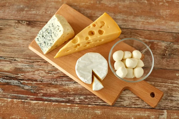 Diversi tipi di formaggio sul tagliere di legno — Foto Stock