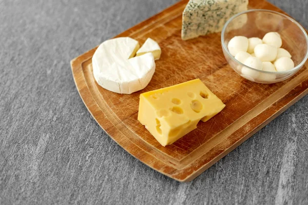 木制切菜板上的各种奶酪 — 图库照片