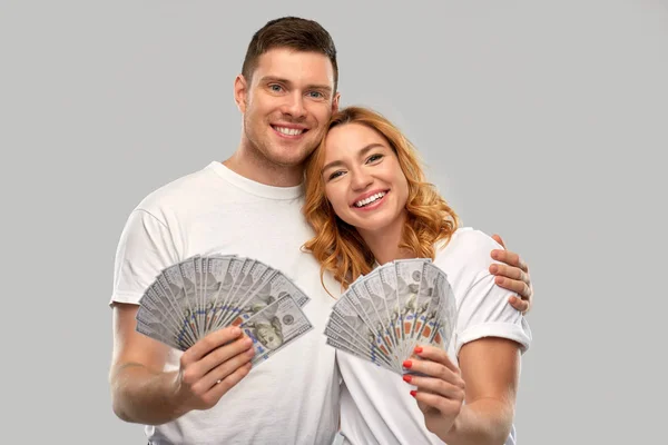 Feliz pareja en camisetas blancas con dinero en dólares — Foto de Stock