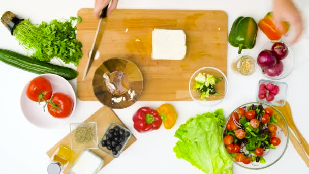 Vrouw koken groente salade met feta en olie — Stockvideo