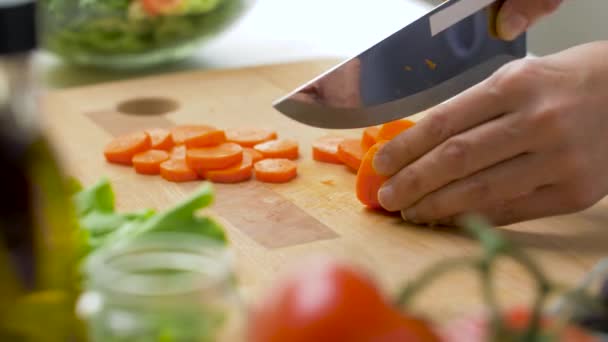 Femme coupant carotte avec couteau de cuisine à la maison — Video