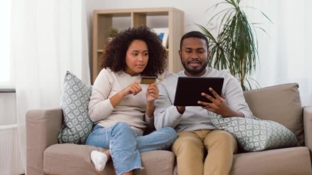 Casal com tablet pc e cartão de crédito em casa — Vídeo de Stock