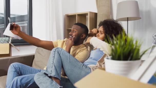 Feliz pareja mudándose a nuevo hogar y tomando selfie — Vídeos de Stock