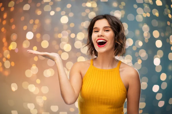 Feliz joven sosteniendo algo en la mano vacía — Foto de Stock